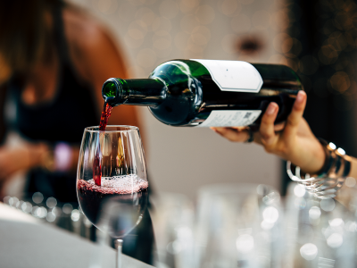 primer-plano-de-la-mano-vertiendo-vino-en-el-vaso